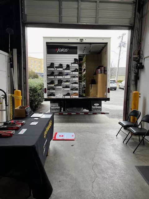 Jalas safety shoe truck parked in a warehouse with the back open and shoes displayed on shelves.
