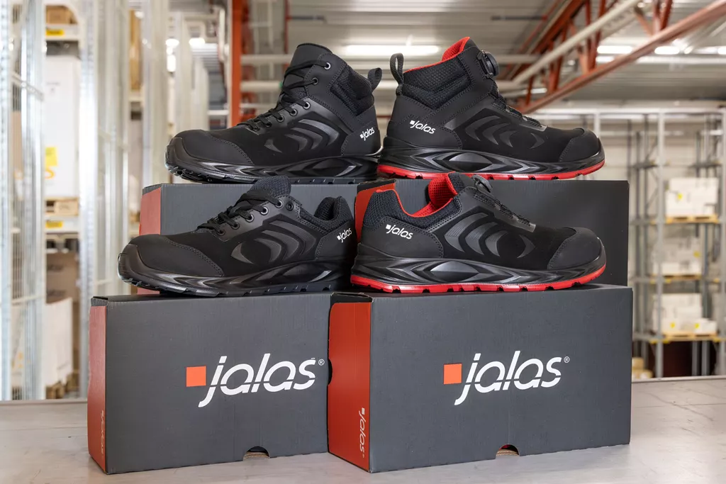 JALAS Flex safety shoes displayed on branded shoe boxes in an industrial warehouse.